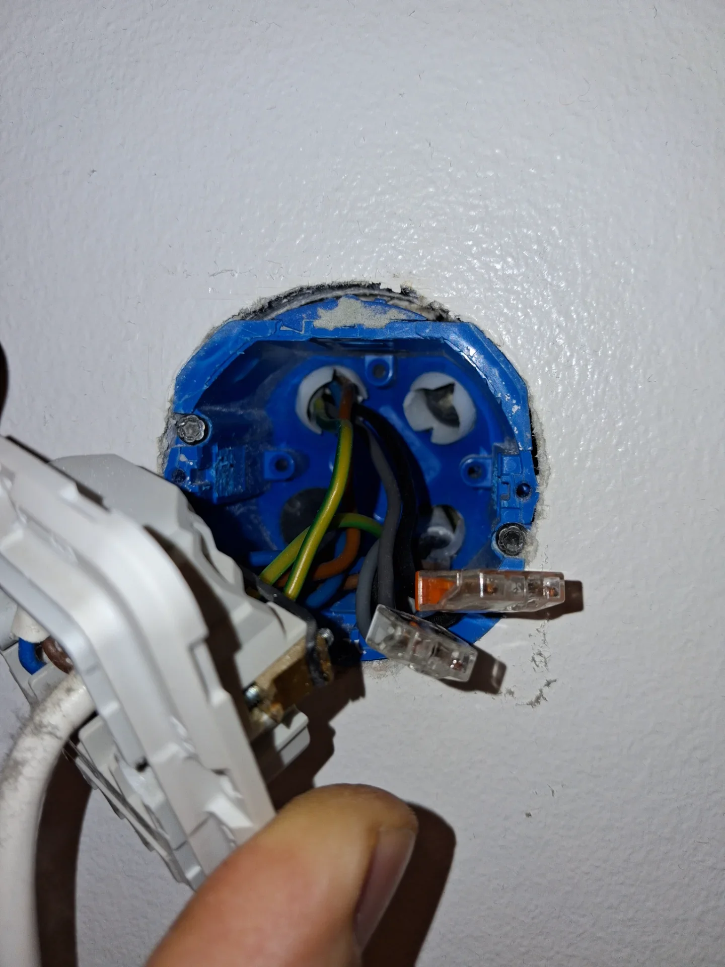 Elektrisk vægudtag under installation med synlige ledninger.